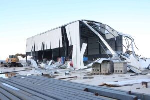 Yıkım alanında büyük metal yapı ve dağınık inşaat malzemeleri görülebilir.