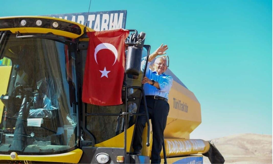 Otomatik tarım makinesi ve Türk bayrağı ile çiftçi, modern tarım teknolojisini temsil ediyor.
